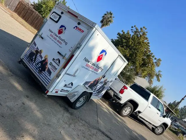 New View Roofing branded trailer and truck on-site